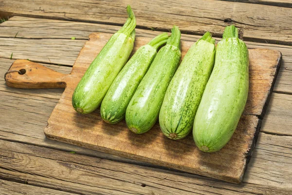 Green zucchini on wooden cutting board — Stock Photo, Image