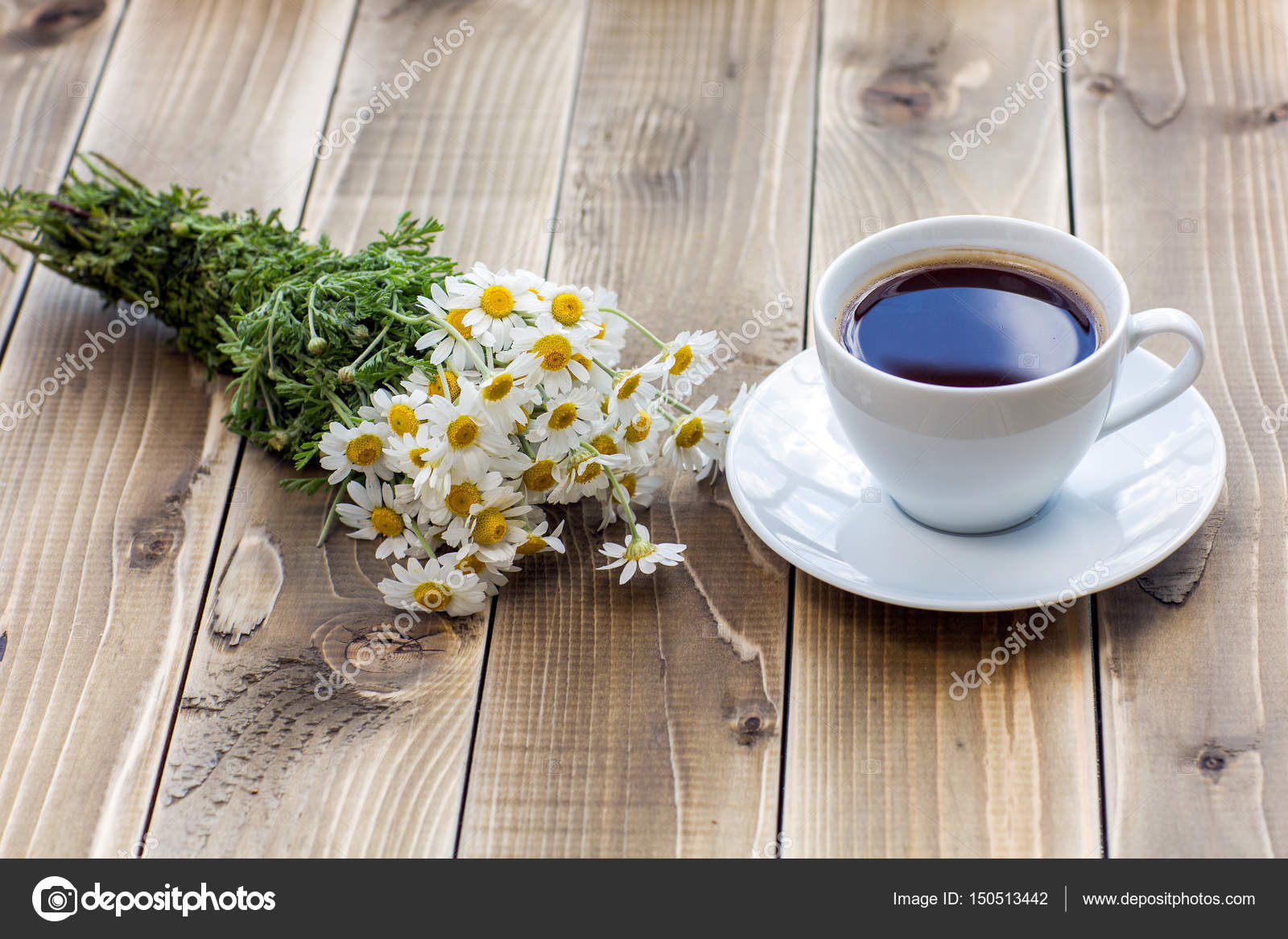 Coffee cup with White flower decoration on wooden table