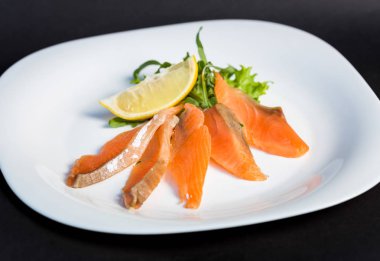 Dilimleri kırmızı balık fileto limon ve yeşillik ile tabak