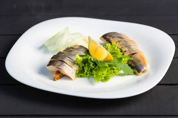 Plato de rebanadas de pescado de arenque con verduras, limón y cebolla —  Fotos de Stock