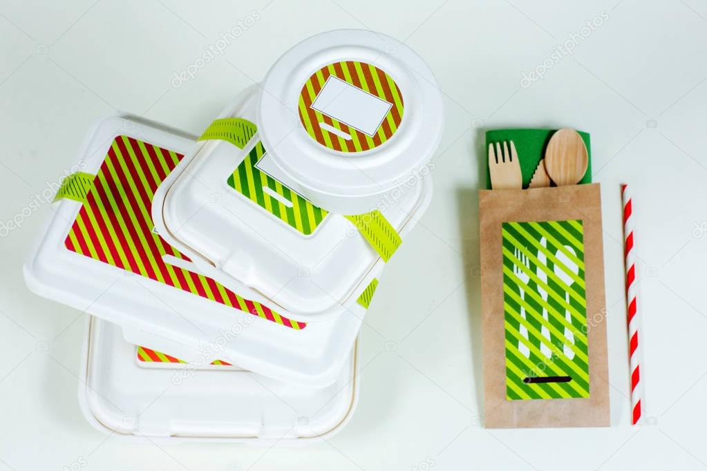 Food boxes and wooden cutlery on white background