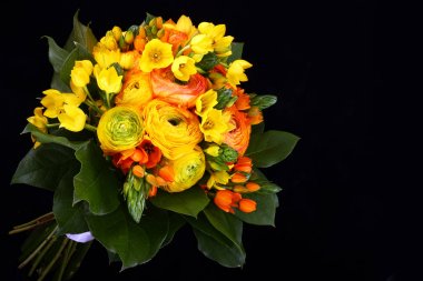 Siyah zemin üzerine yeşil yaprakları ile buket sarı ranunkulyus