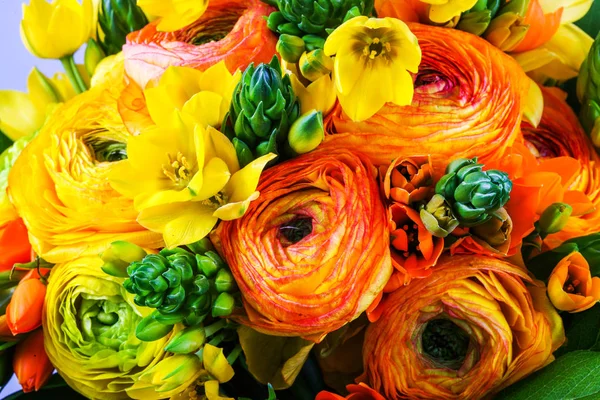 Bouquet giallo e arancione ranunkulyus con foglie verdi — Foto Stock