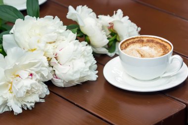 Ahşap masaya çiçek ile kahve