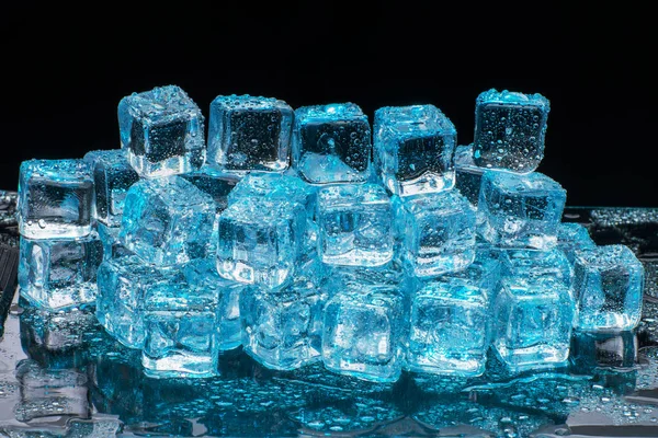 Siyah ıslak masada buz küpleri. Seçici odak