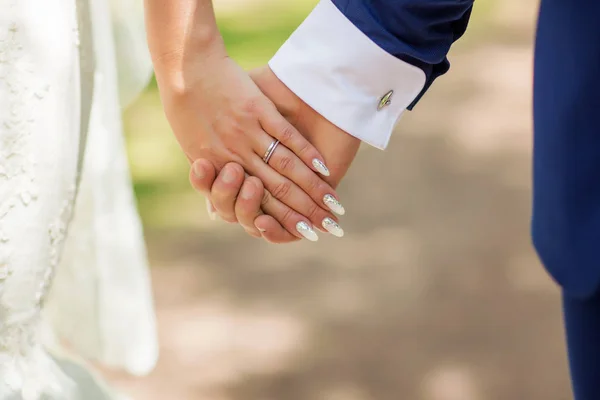 Свадебная тема, мужчина и женщина держатся за руки с красивым маникюром аккуратно — стоковое фото