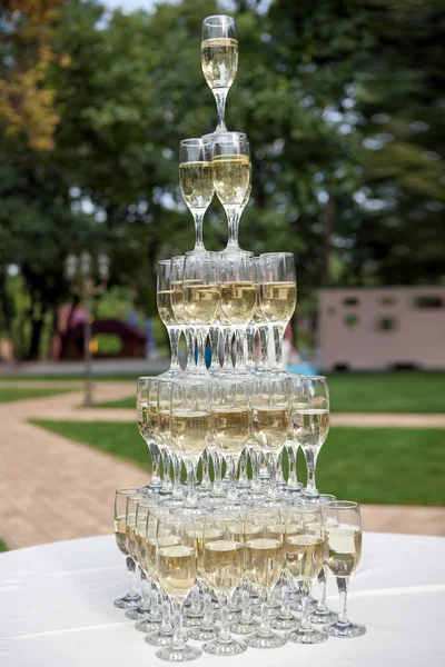 Champagne glasses standing in a tower at the party