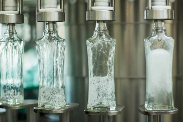 Botellas con una bebida cerrada con una tapa de rosca. Fábrica para la producción de bebidas alcohólicas — Foto de Stock