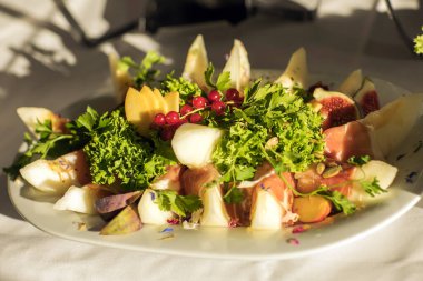 Porselen tabak üzerinde kavun İtalyan jambon ve fesleğen yaprakları