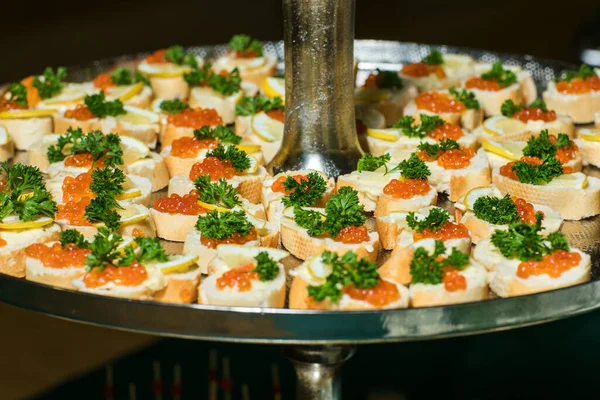 Sandwiches con caviar. Caviar rojo. Comida en la mesa de vacaciones. Snacks en un plato . —  Fotos de Stock