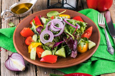 Sebzeli salata ve ahşap masada yeşiller.