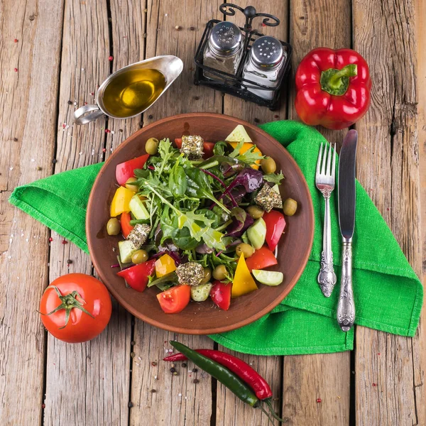 Salad with vegetables and greens on wooden table — Stock Photo, Image