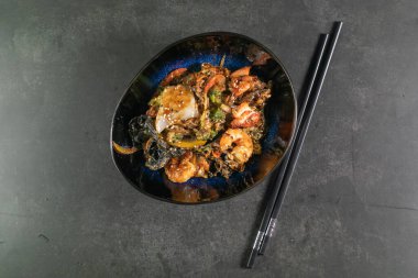 Tabağında deniz ürünleri olan Asya eriştesi.