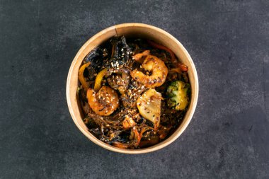 Tabağında deniz ürünleri olan Asya eriştesi.