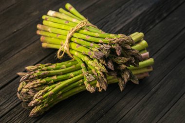 Kırsal ahşap bir masada taze yeşil kuşkonmaz mızrakları