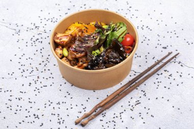 Beyaz masada tavuk ve sebze dolu bir kase..