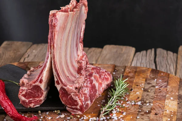 Raw lamb meat in a carnage on wooden background