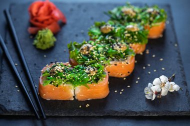 Suşi, deniz ürünleri ve Chuka salatasıyla birlikte. Yeşil suşi. Üst Manzara. Metnin için boş yer.