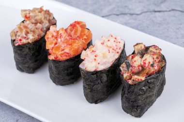 Siyah arka planda geleneksel taze Japon suşisi siyah taş üzerinde Gunkan ebi.