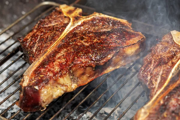 Portatif bir yaz barbeküsünde et ve sebze seçimi ön planda biberiye soslu sulu yağsız biftek üzerine odaklanmış..