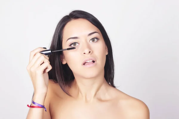 Jonge vrouw aanbrengen mascara op haar wimpers — Stockfoto