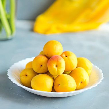 Taze ve olgun kayısı gri arka plan üzerinde. Mevsim meyveleri, summ