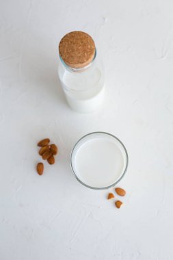 Bazı badem sütü. Üstten Görünüm. Beyaz beton zemin. Sağlıklı gıda kavramı.