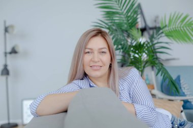 Sarışın kadın kanepede yatıyor.