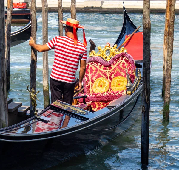 Veneza, Itália. Gondolier em uma camisa vermelha listrada e chapéu em um moo — Fotografia de Stock