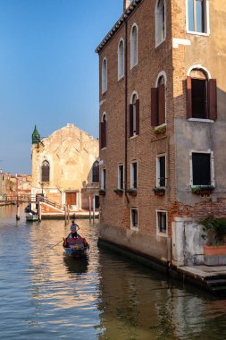 Venedik, İtalya. Gondolcu dar bir kanalda gondol yönetiyor.