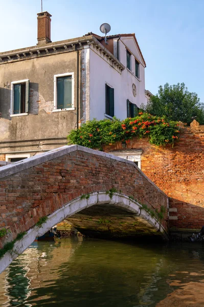 Venecia, Italia. Un pequeño puente privado sobre el canal en el fondo de casas antiguas — Foto de Stock