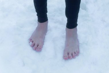 Frozen reddened barefoot male feet in the snow clipart