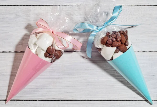 Праздничные подарки из сладостей и зефира упакованы в синие и розовые конусы Стоковое Фото