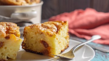 Beyaz tabakta ve tencerede süzme peynir güveci.