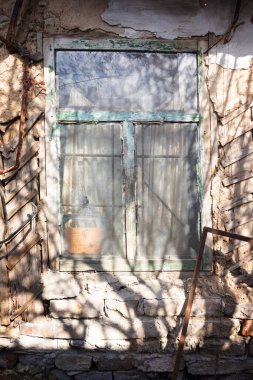 Eski ahşap pencere kil bir evde harap bir duvarda.