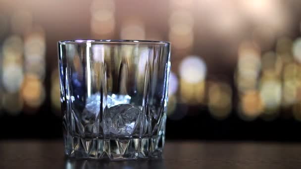 Виски наливают на лёд в замедленной съемке. — стоковое видео