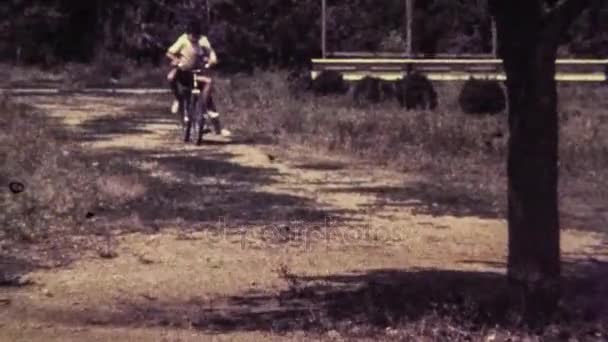 Película retro de 16 mm. Niños en bicicleta . — Vídeo de stock