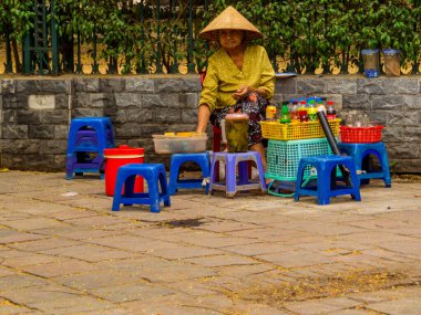 Hanoi, Vietnam - 19 Aralık 2019: Yaşlı bir kadın eski kasabadaki bir sokak restoranında.