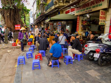 Hanoi, Vietnam - 19 Aralık 2019: İnsanlar eski kasabadaki geleneksel sokak restoranının önünde oturuyorlar.