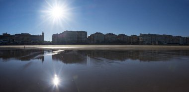 Sun reflected in the water of the beach of San Sebastian. clipart