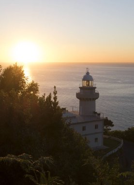 Deniz feneri ve günbatımı sahil üzerinde