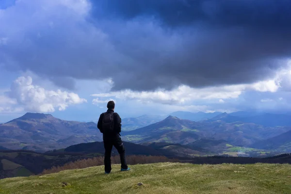 Man walking with mountains in the background, Aiako Harriak natural park