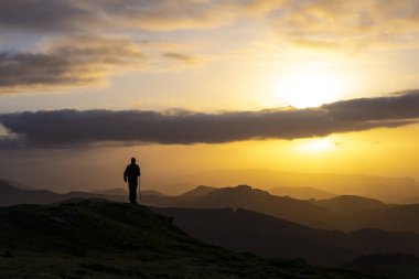 Adam başarı bir dağın tepesinde sunrise kutlama.