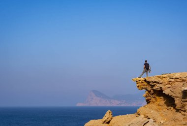 Cala Bassa, Ibiza, Balear Adaları 'ndan manzaraya ve denize bakan kıdemli turist