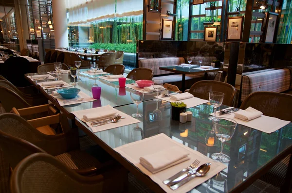 SINGAPUR - 23 de julio de 2016: restaurante de lujo The Colony en un hotel de cinco estrellas The Ritz-Carlton Millenia Marina Bay, mesa de comedor —  Fotos de Stock