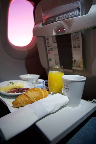 ФРАНКФУРТ, ГЕРМАНИЯ - 21 ЯН 2017: завтрак на самолете в бизнес-классе Lufthansa со свежим кофе, апельсиновым соком, сыром и беконом — стоковое фото