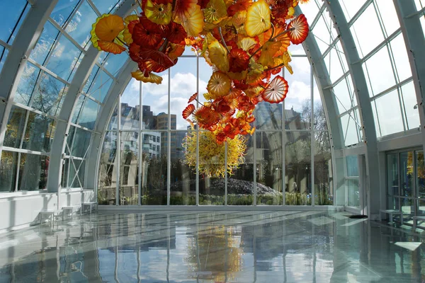 SEATTLE, WASHINGTON, EUA - JAN 24th, 2017: Museu Chihuly Garden and Glass com uma das maiores esculturas de Dale Chihulys suspensas do teto da estufa. Os edifícios da cidade são vistos em — Fotografia de Stock