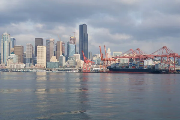 Seattle, Washington, Usa - 25 Jan 2017: En vy på Seattle downtown från vattnen i Puget Sound. Bryggor, skyskrapor och hamnen bryggor i Seattle staden före solnedgången på en molnig dag — Stockfoto