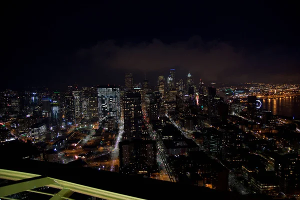 SEATTLE, WASHINGTON, Estados Unidos - 23 ENE 2017: skyline del centro de Seattle, vista desde lo alto de la Aguja Espacial durante una noche nublada, luces de la ciudad — Foto de Stock