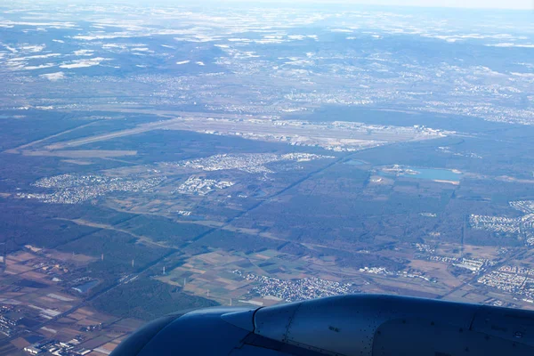 FRANKFURT, ALLEMAGNE - 20 JAN 2017 : Vue par la fenêtre de l'avion sur l'aile du jet, vue sur la ville enneigée de Francfort-sur-le-Main, aéroport FRAPORT en arrière-plan — Photo